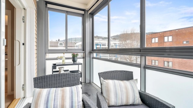 Skyveglassene på balkongen gir fleksibilitet og beskyttelse mot vær og vind, slik at uterommet kan nytes lenger.