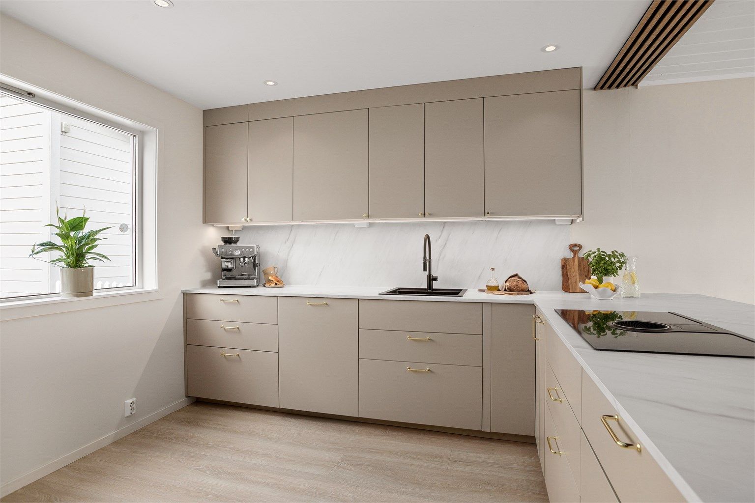 Delikat kjøkkeninnredning fra 2023 innredet i slette beige fronter