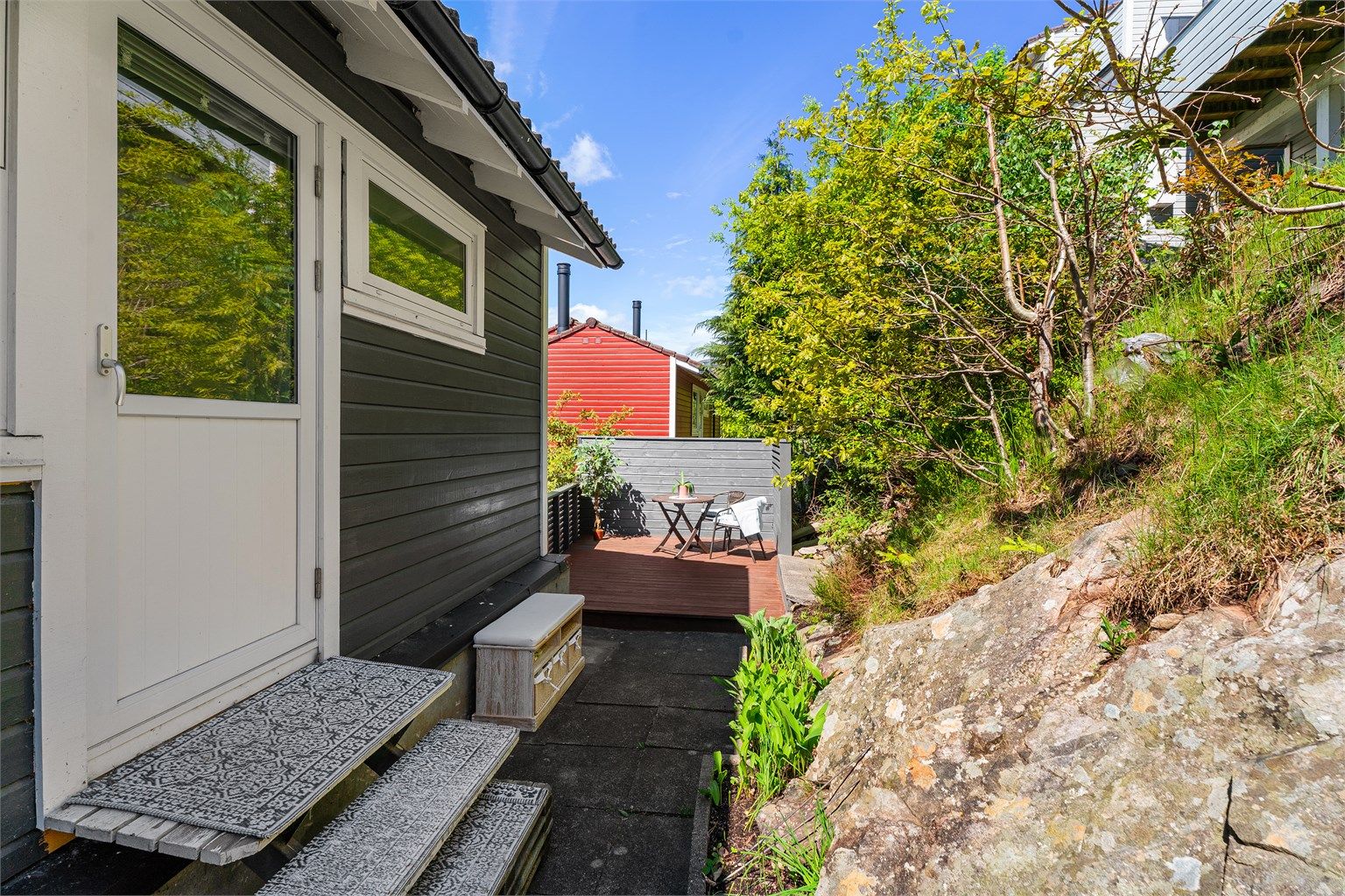 Uteområdet bak er opparbeidet med platting og levegg. 