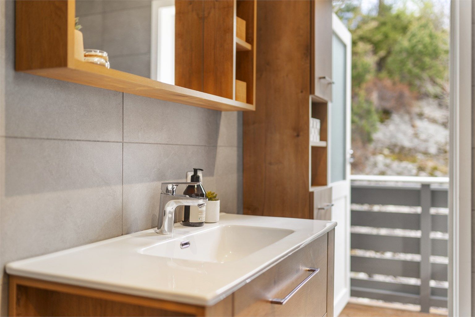 Baderomsinnredningen har smarte og praktiske oppbevaringsløsninger og det er direkte utgang fra badet til nordvendt balkong