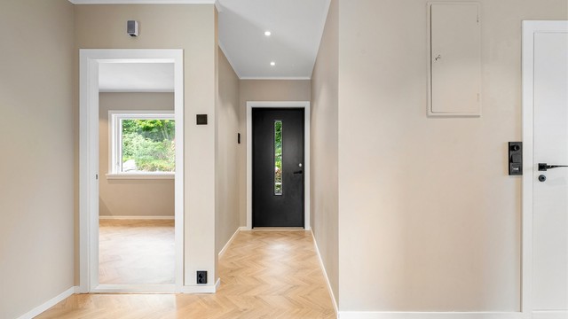 Entréen i første etasje har ny ytterdør fra 2026 og downlights i himling.