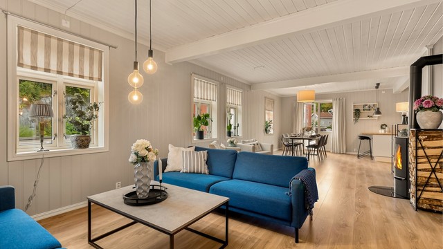 De store vinduene i stua er som smykker i rommet. Det er valgt en enkel stripet gardinkappe som står fint til interiøret.