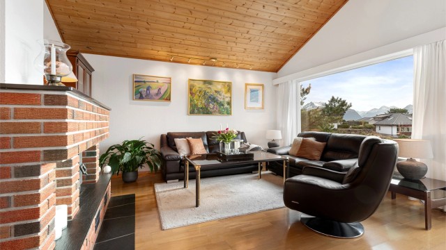 Sofakroken på stuen med murt peis i teglstein