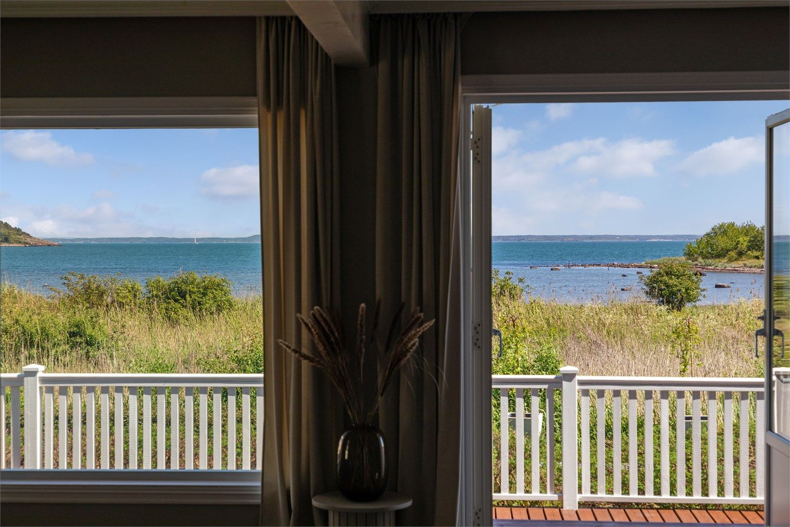 En sjøvendt utsiktsbalkong på ca. 11 kvm med utgang fra hovedsoverommet, en deilig, overbygd uteplass forlange sommermorgener i solen.