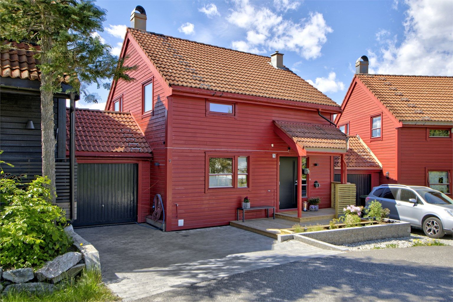 Pent opparbeidet inngangsparti med garasje (med elbil-lader) og plass til parkeringsplass på egen gårdsplass - god plass til gjesteparkering rett ved boligen