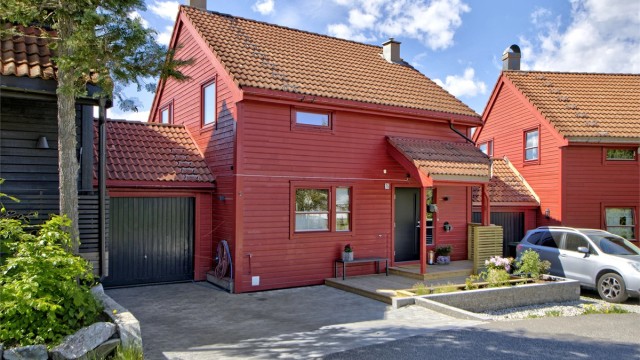 Pent opparbeidet inngangsparti med garasje (med elbil-lader) og plass til parkeringsplass på egen gårdsplass - god plass til gjesteparkering rett ved boligen