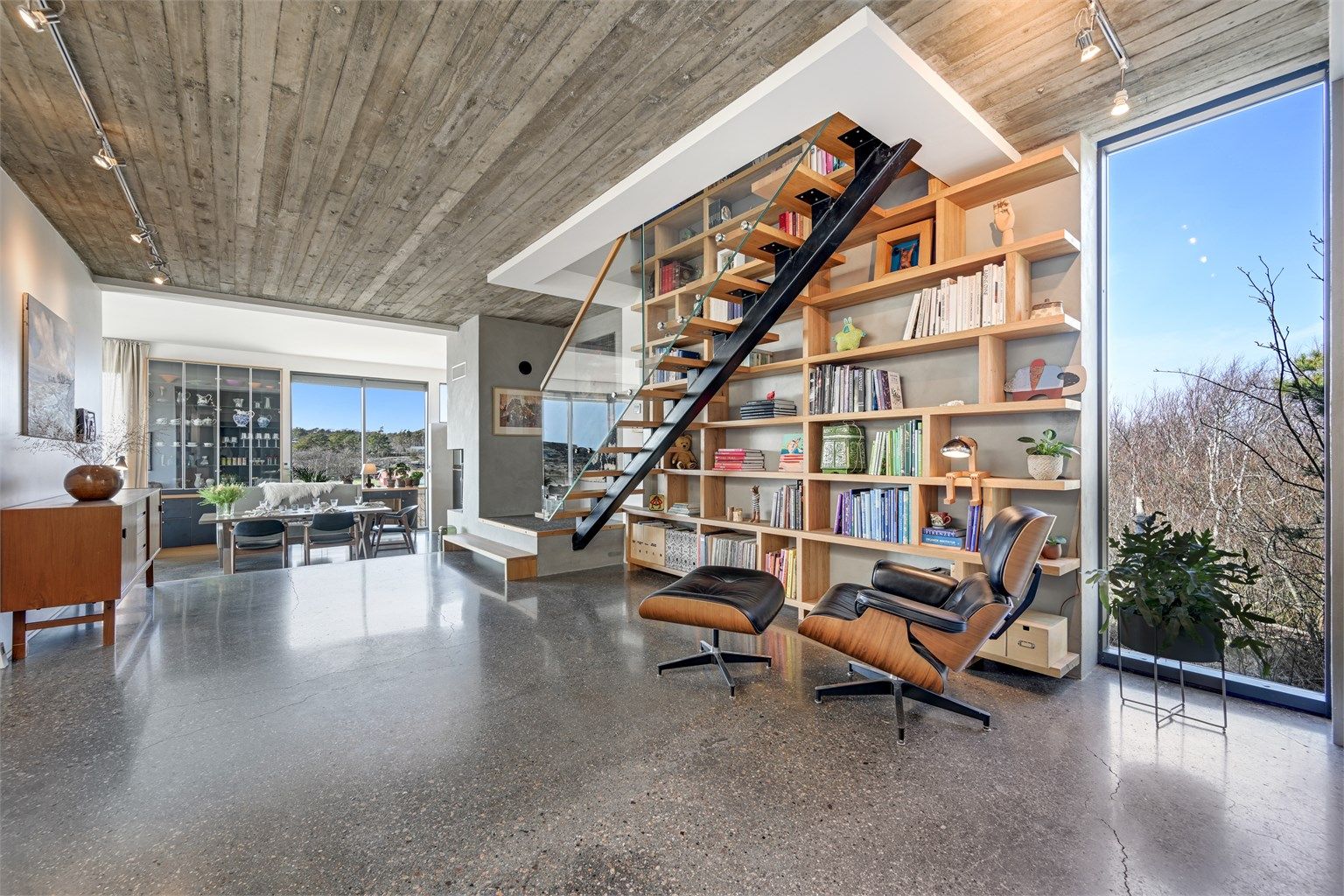 Ståltrappen med trinn i tre og glassrekkverk fra 2022 er et skulpturelt element i rommet.