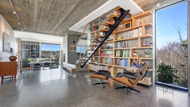 Ståltrappen med trinn i tre og glassrekkverk fra 2022 er et skulpturelt element i rommet.