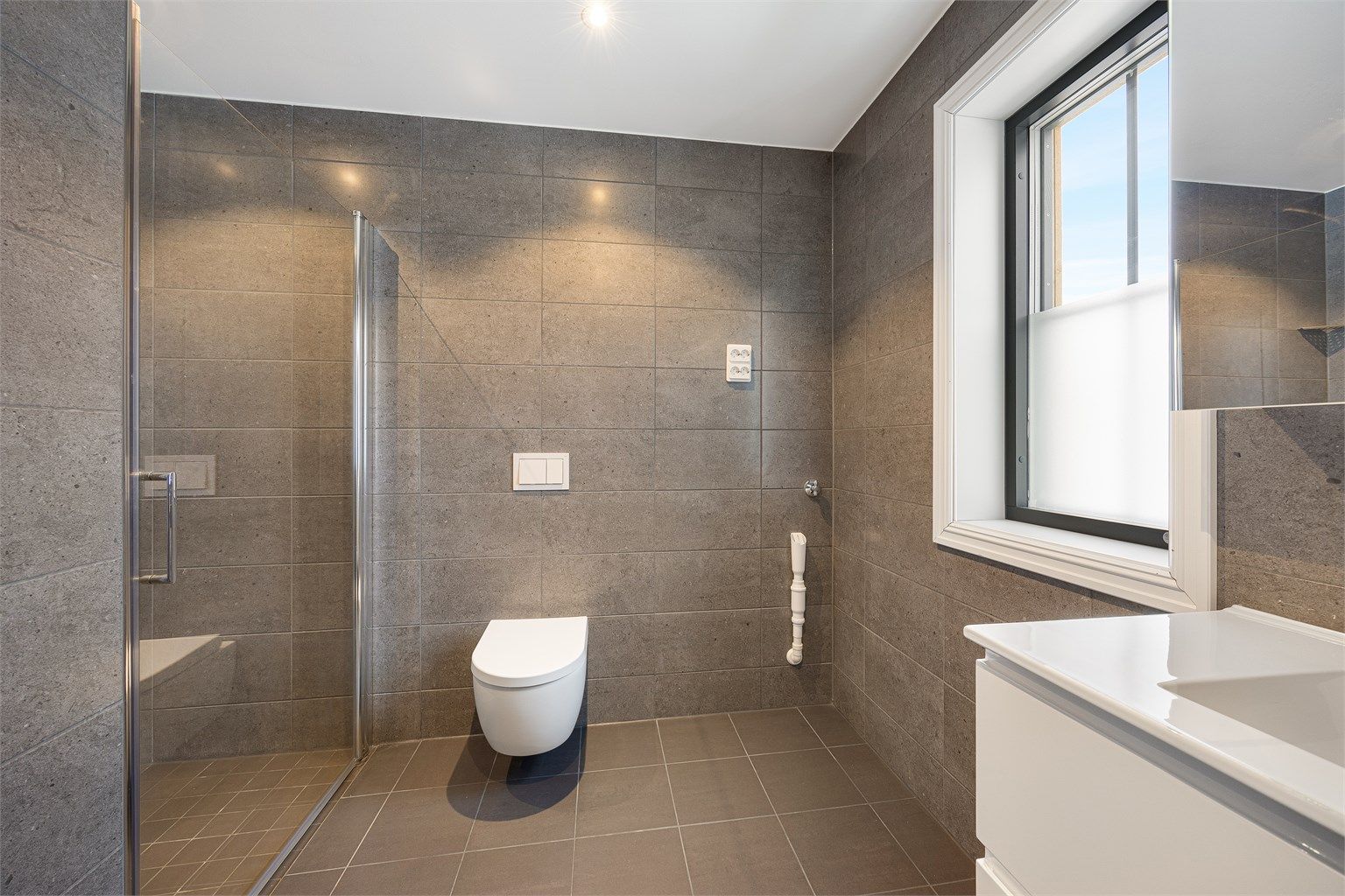 Badet har behagelige varmekabler i gulvet og opplegg for vaskemaskin.