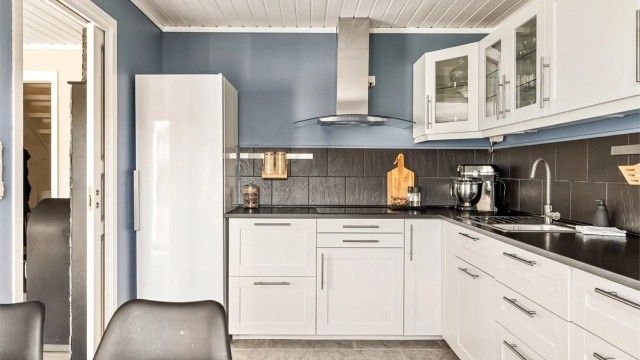 Kjøkkeninnredning med profilerte fronter, laminat benkeplate og godt med skapplass.