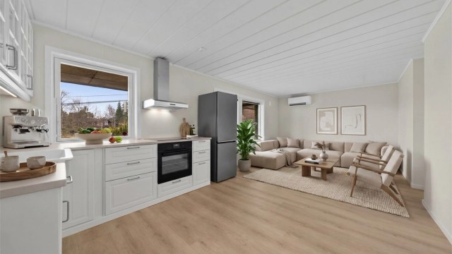 Stuen i underetasjen har en åpen løsning mot kjøkkenet, noe som skaper et moderne og sosialt allrom. Her digitalt møblert for å vise mulighetene.