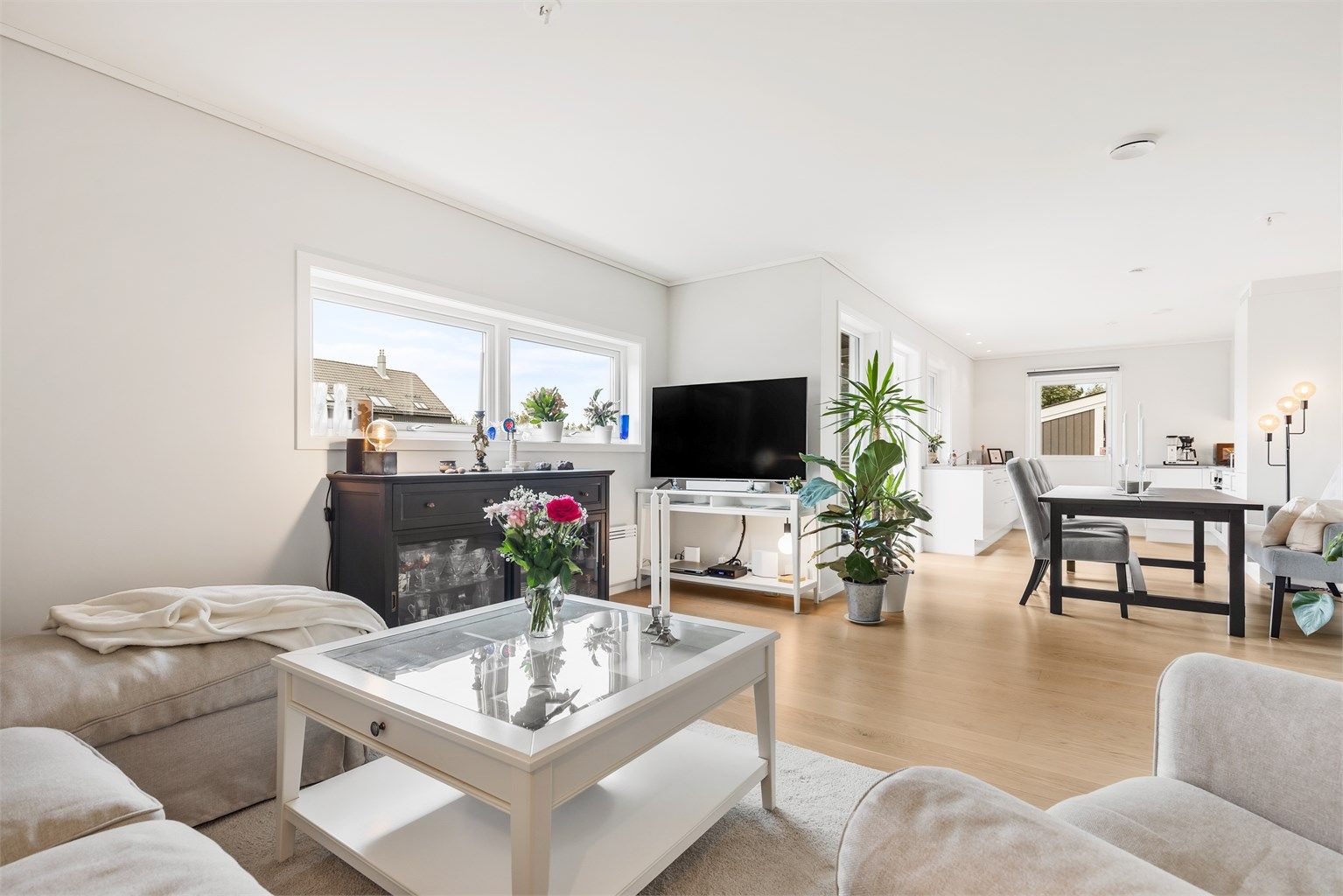 Romslig stue med flere møbleringsalternativer. Plass til sittegruppe, TV-område og stort spisebord i spisestuedelen.