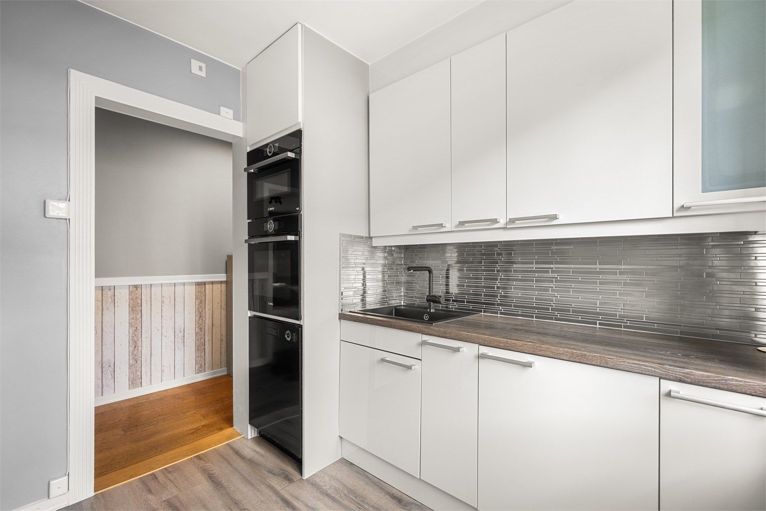 Stilrent kjøkken med glatte fronter og laminert benkeplate.