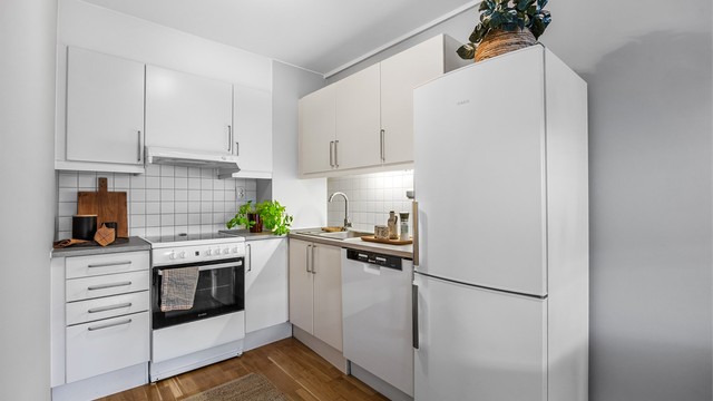 Kjøkken - innredning fra byggeår med glatte lyse fronter