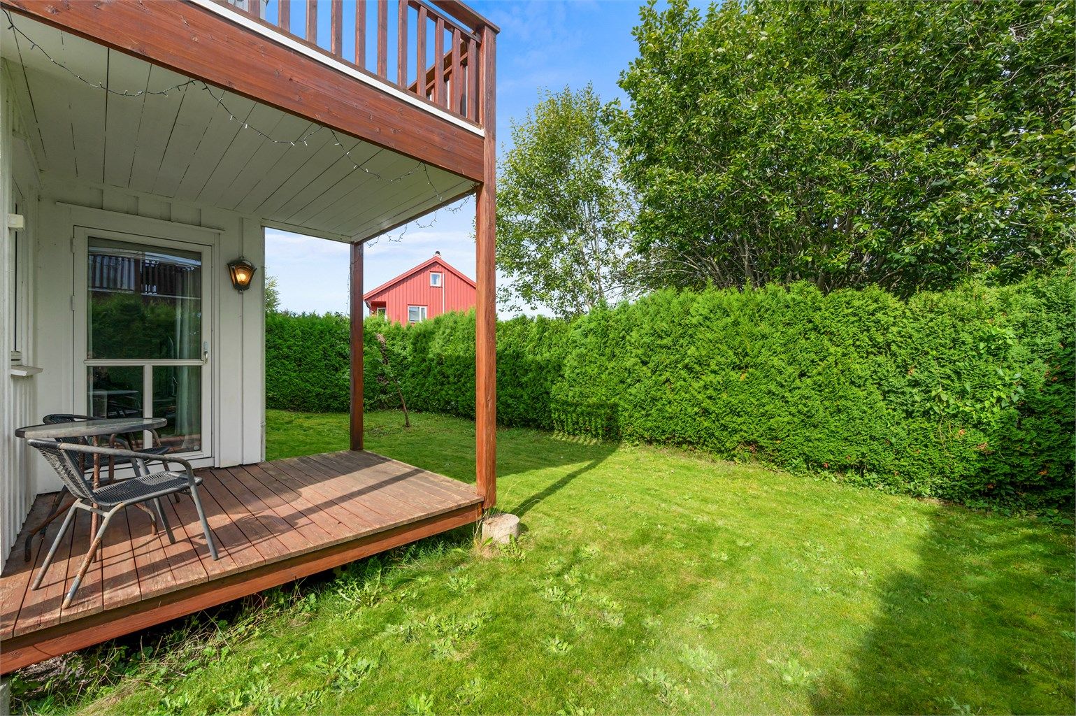 Hagen er inngjerdet av plantet hekk som gir en skjermet uteplass. Overbygd terrasse med adkomst fra stuen. 