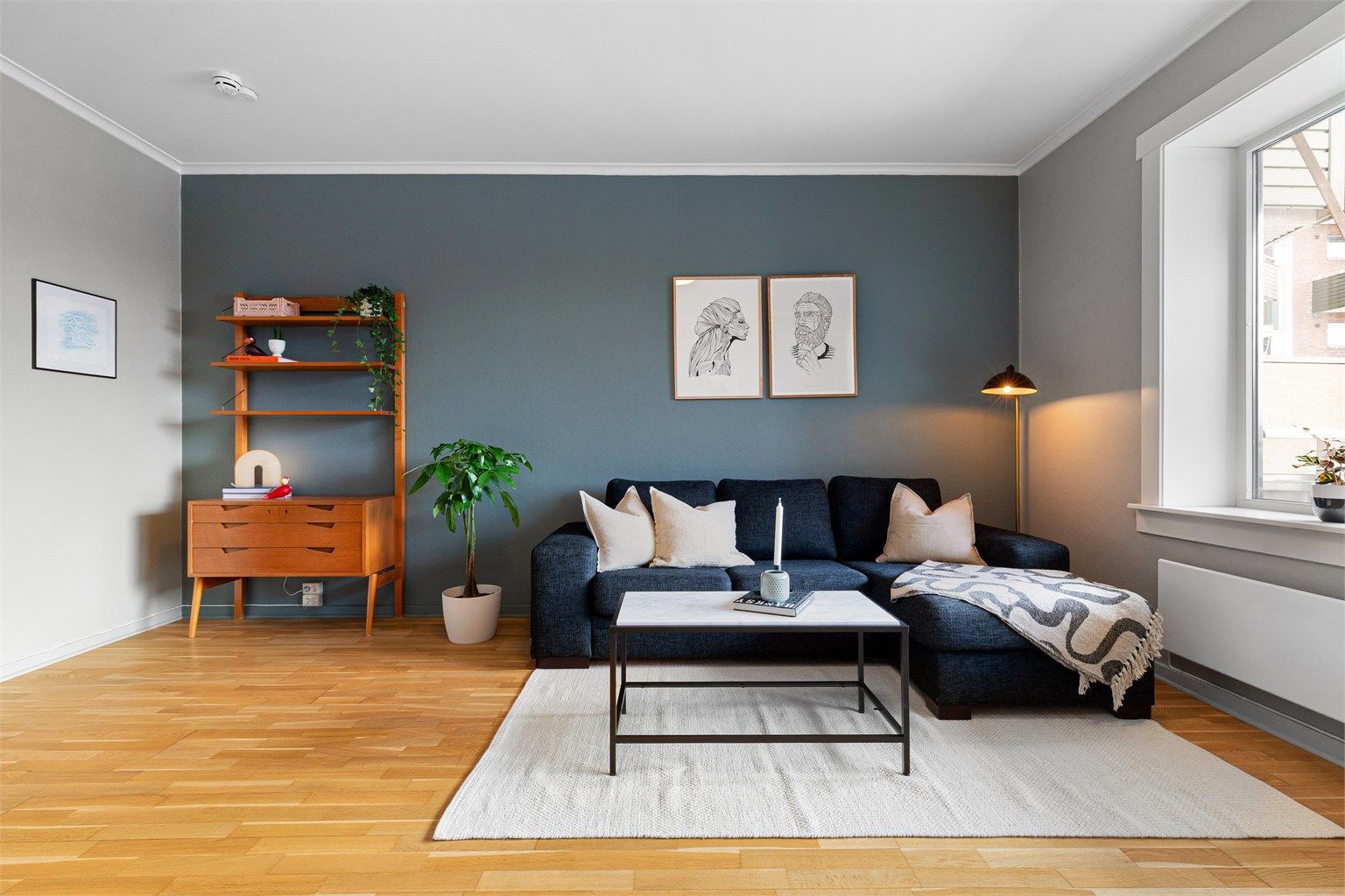  Romslig stue med god plass til både sofa, spisebord, peis og utgang til balkong.