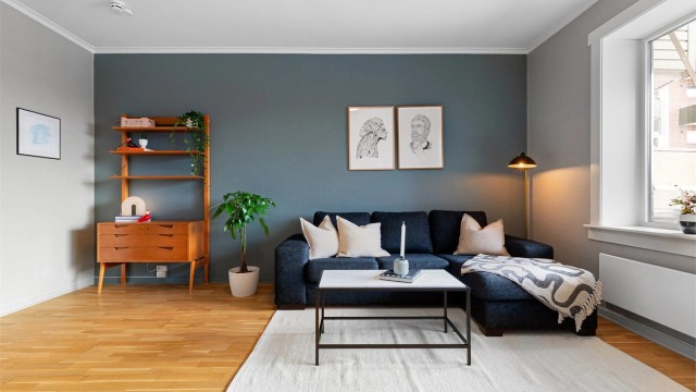 Romslig stue med god plass til både sofa, spisebord, peis og utgang til balkong.