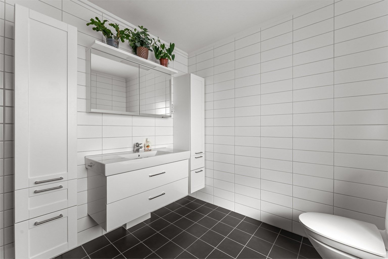 Flott baderom med fliser på gulv med gulvvarme, fliser på vegger og malt himling