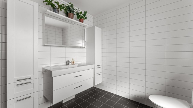 Flott baderom med fliser på gulv med gulvvarme, fliser på vegger og malt himling