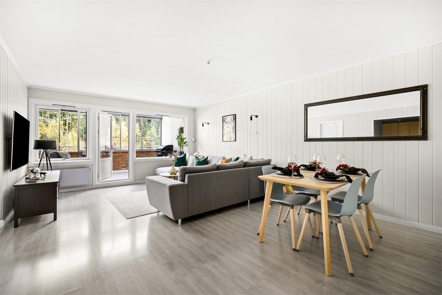 Fint utsyn til skog og mark sees fra både sofakroken og spisebordet innerst i stuen. 