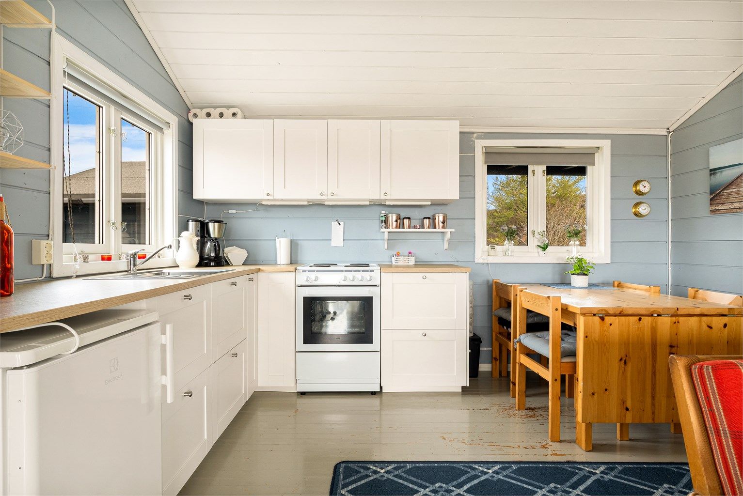 Åpen kjøkkenløsning med Ikea innredning fra ukjent årstall med profilerte fronter og benkeplate med laminat overflate