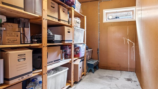 Romslig bod i underetasjen med rikelig hylleplass til oppbevaring.