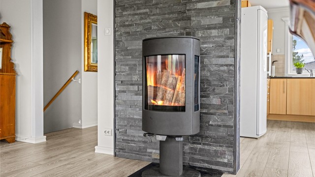 En moderne peisovn gir både varme og en hyggelig atmosfære i stuen.