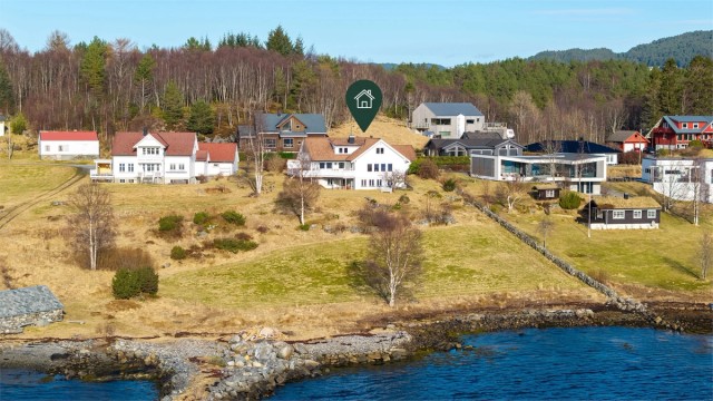 Dronebilde av eiendommen og nærområdet som viser den sjønære beliggenheten