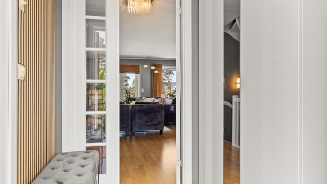 Den romslige hallen gir god plass til garderobeløsninger og har doble glassdører inn mot første etasje.