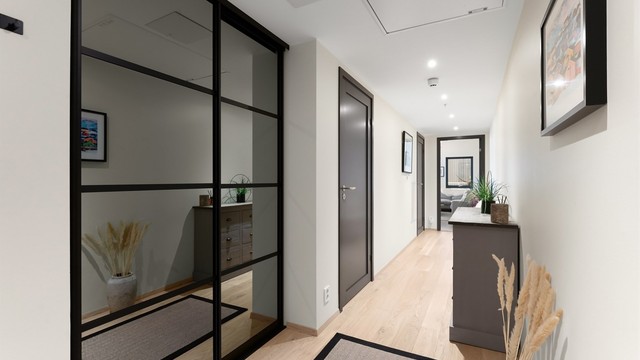 Skyvedørsgarderobe med speilfronter gir rikelig med oppbevaringsplass i gangen.