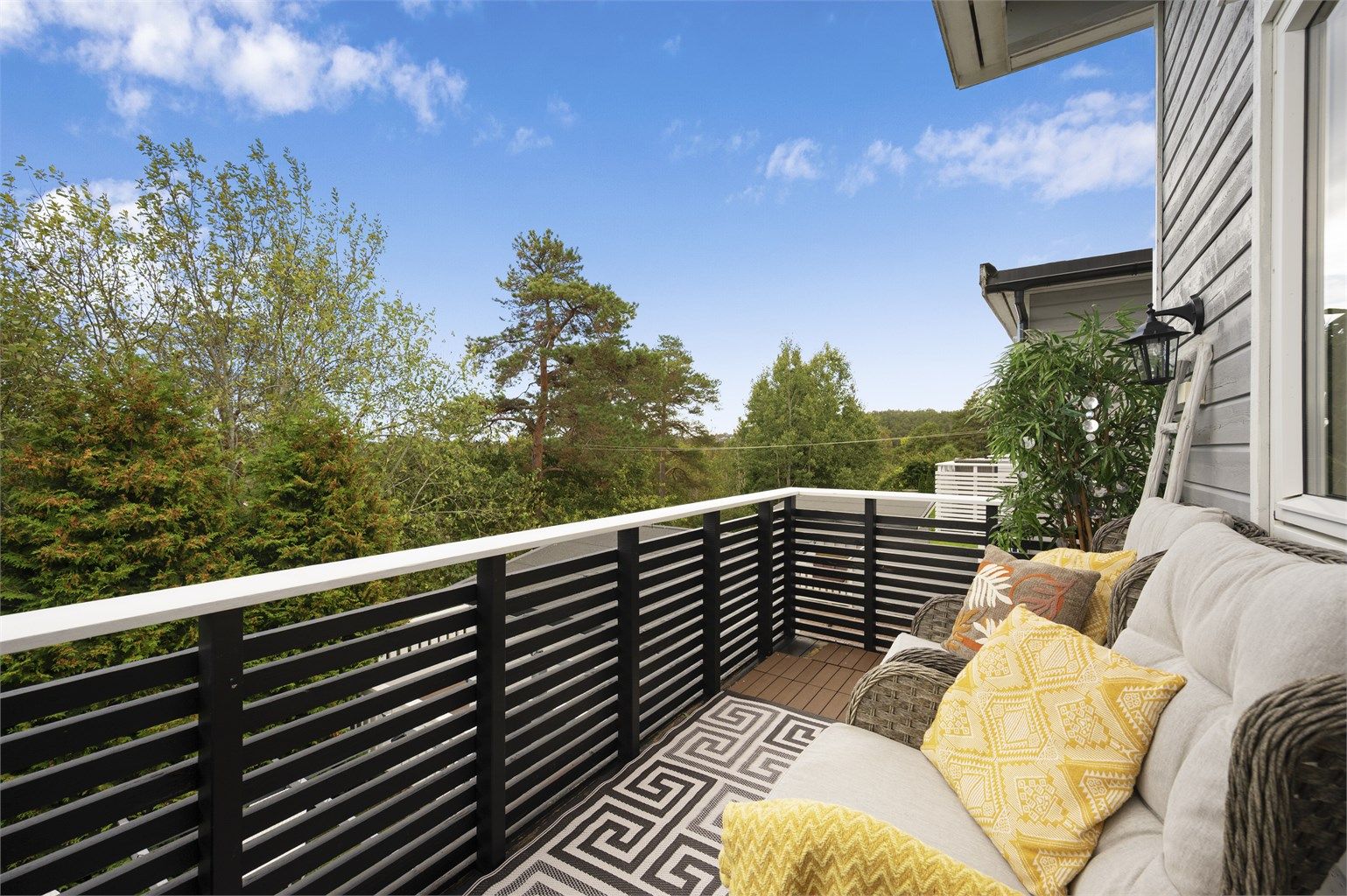 Balkongen i andre etasje har terrassebord på gulvet og plass til en trivelig sittegruppe. Herfra er det fint utsyn mot naturen og grønne omgivelser.