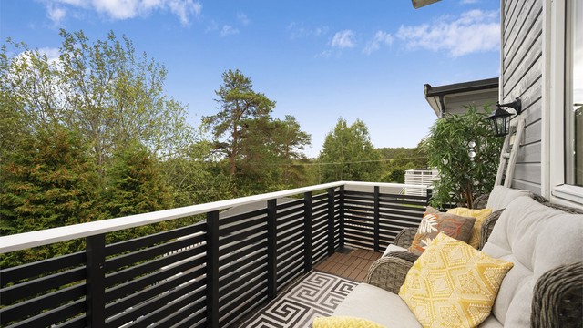 Balkongen i andre etasje har terrassebord på gulvet og plass til en trivelig sittegruppe. Herfra er det fint utsyn mot naturen og grønne omgivelser.