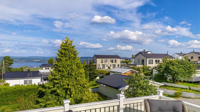 Flott utsyn over nærområdet og vannet fra verandaens rekkverk.