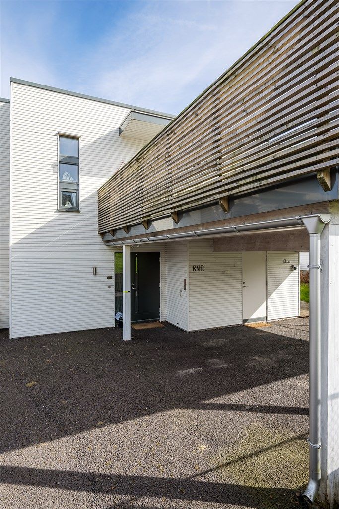 Praktisk dobbel carport med elbillader og en tilhørende sportsbod på 5 m² ved inngangspartiet.