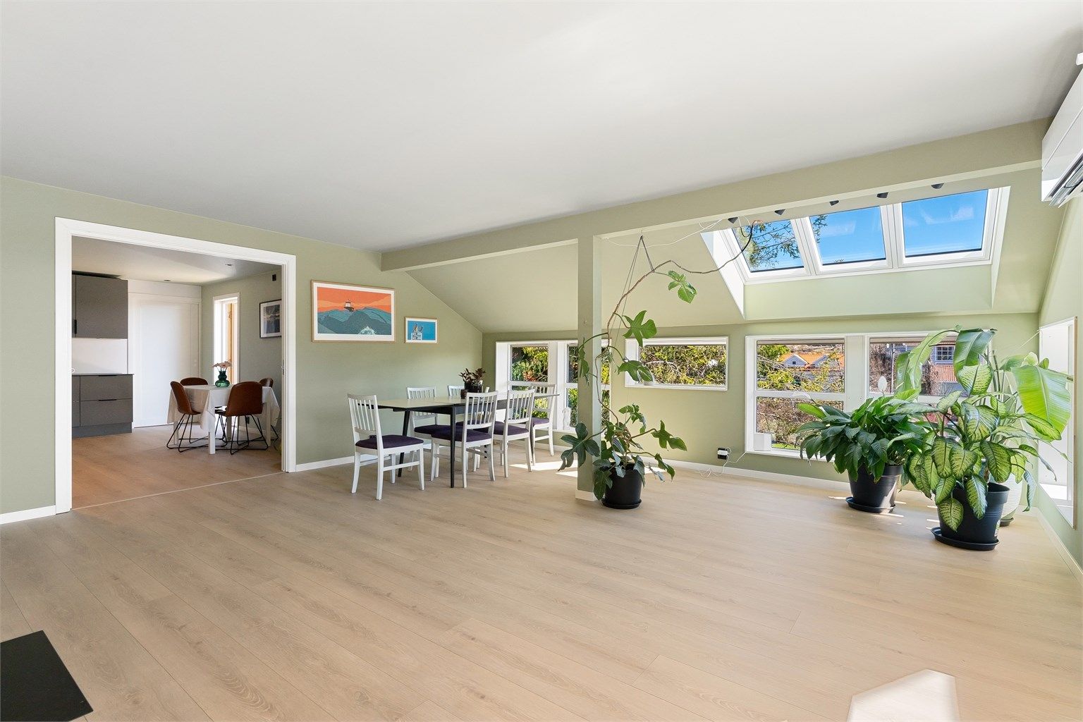 Rommet har en kombinasjon av store vinduer og takvinduer som gir rikelig med dagslys.