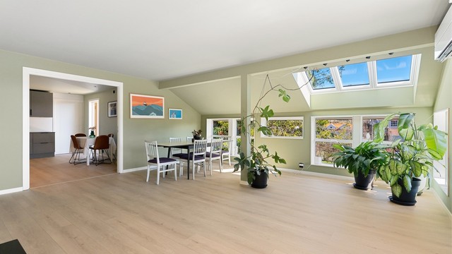 Rommet har en kombinasjon av store vinduer og takvinduer som gir rikelig med dagslys.