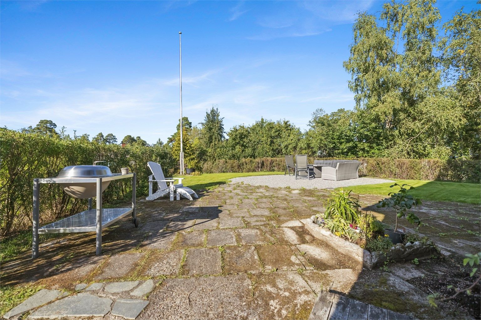 Eiendommen er pent opparbeidet med gressplen, trær, prydbusker og diverse beplantning.