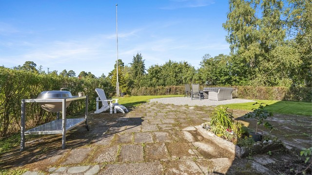 Eiendommen er pent opparbeidet med gressplen, trær, prydbusker og diverse beplantning.