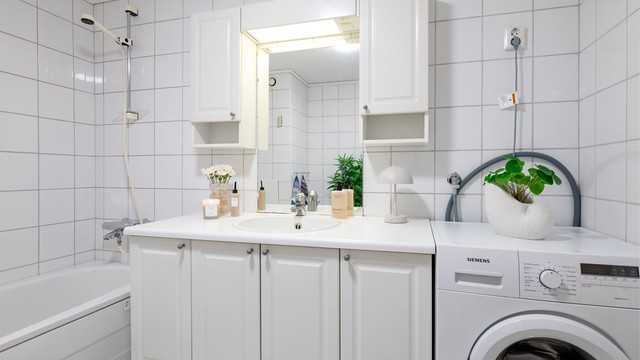 Hvit baderomsinnredning med god skapplass. Nedfelt vask og overskap med lys. Plass til vaskemaskin på badet. Varmekabler i gulv.