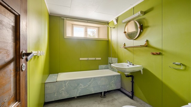 Bad i underetasjen innredet med badekar, servant og toalett.