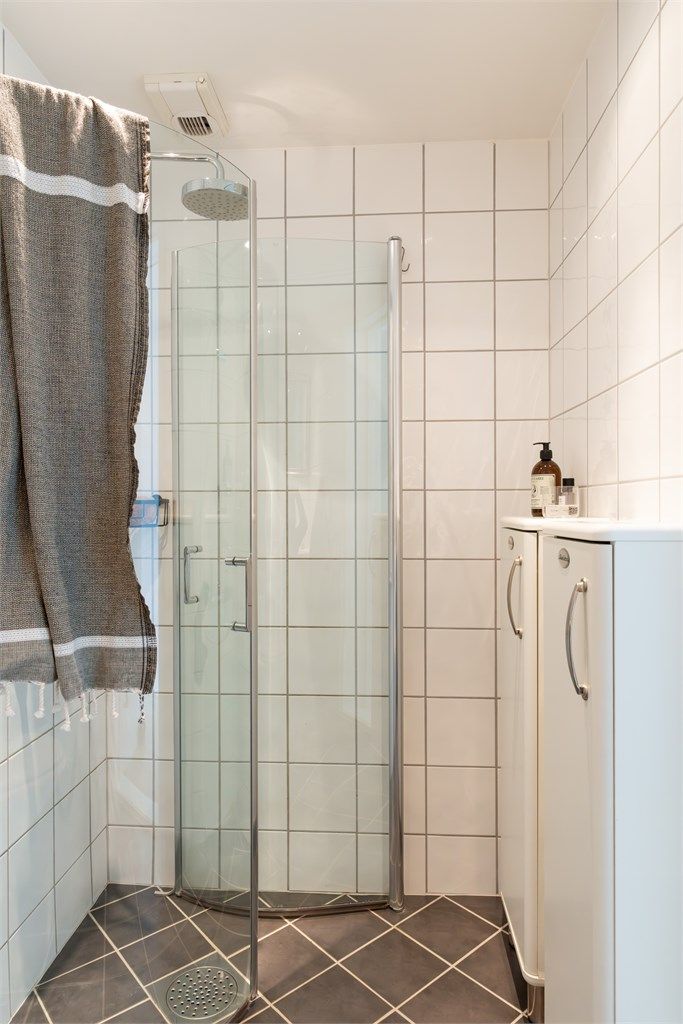 Badet er utstyrt med gulvstående toalett og dusjhjørne med glassvegg, og innfellbar glassdør. 