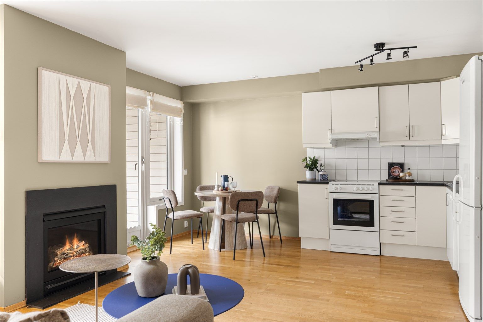 Åpen stue- og kjøkkenløsning med en stemningsfull gasspeis. Her er det plass til både spisebord og sofagruppe.