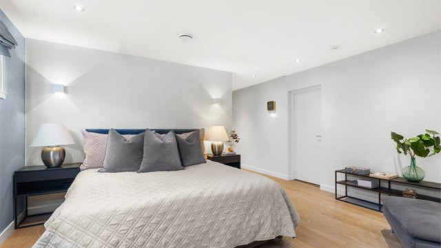 Videre har soverommet direkte adkomst til et praktisk walk-in-closet med innebygde garderobeskap. Både soverommet og omkledningsrommet har en-stavs parkettgulv, elektrisk gulvvarme og downlights, noe som gir god komfort og et moderne uttrykk.