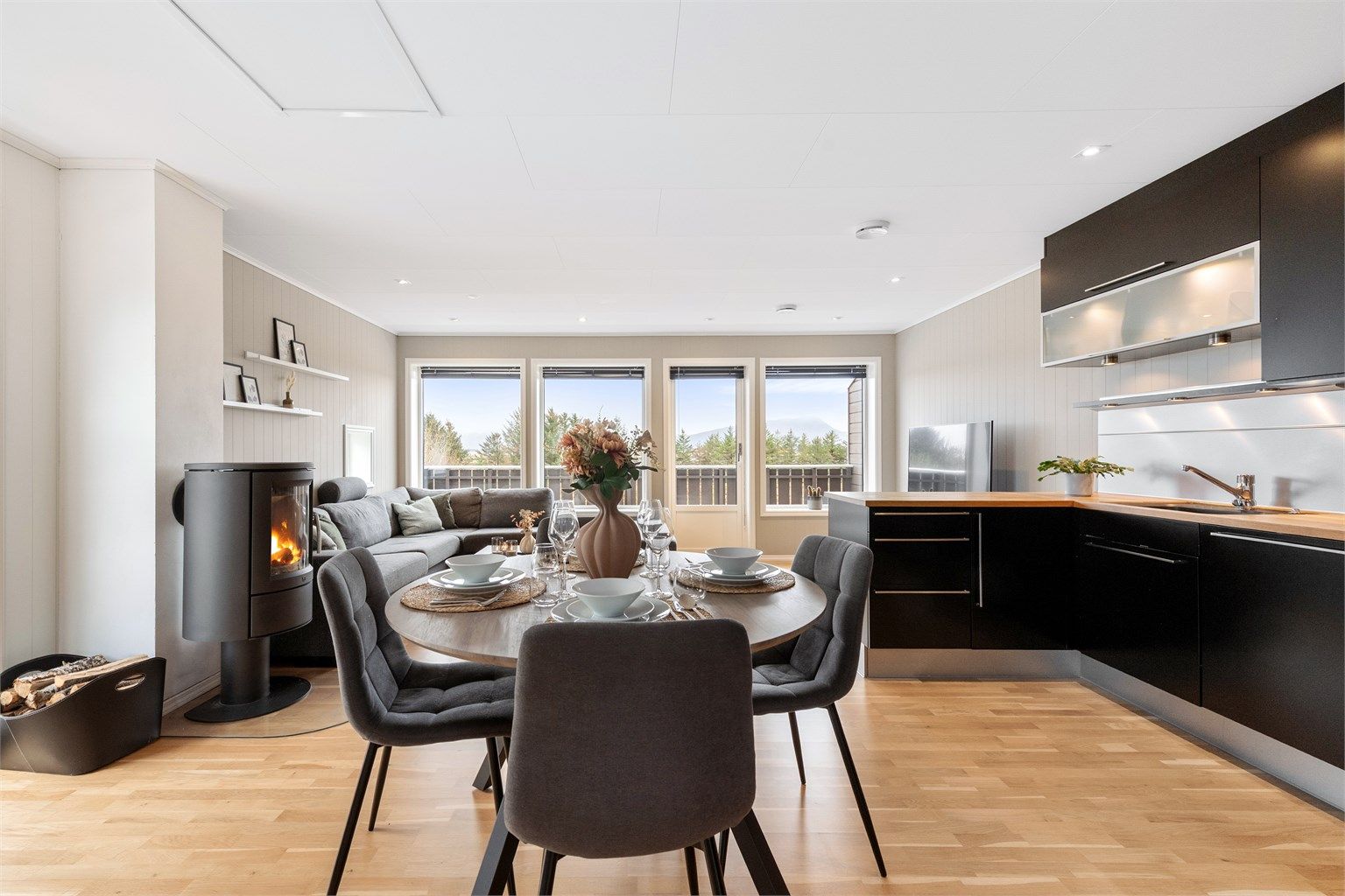 Gode vindusflater sørger for at rommet får godt med naturlig lys, i tillegg til spotter i taket og kjøkkeninnredningen. Legg og merke til luke opp til kaldloftet