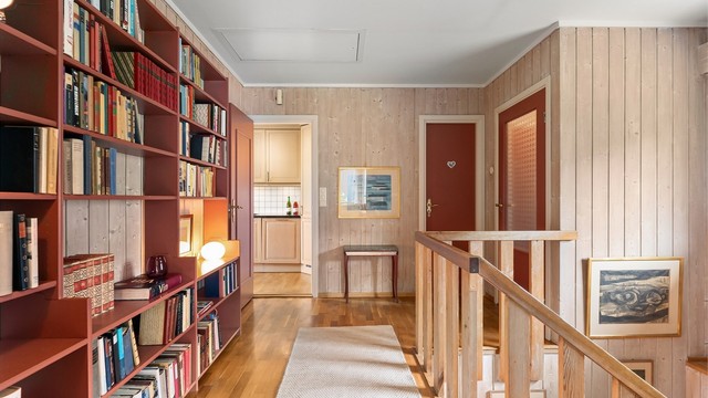 Plassbygde bokhyller gir rikelig med oppbevaringsplass og karakter til gangen.