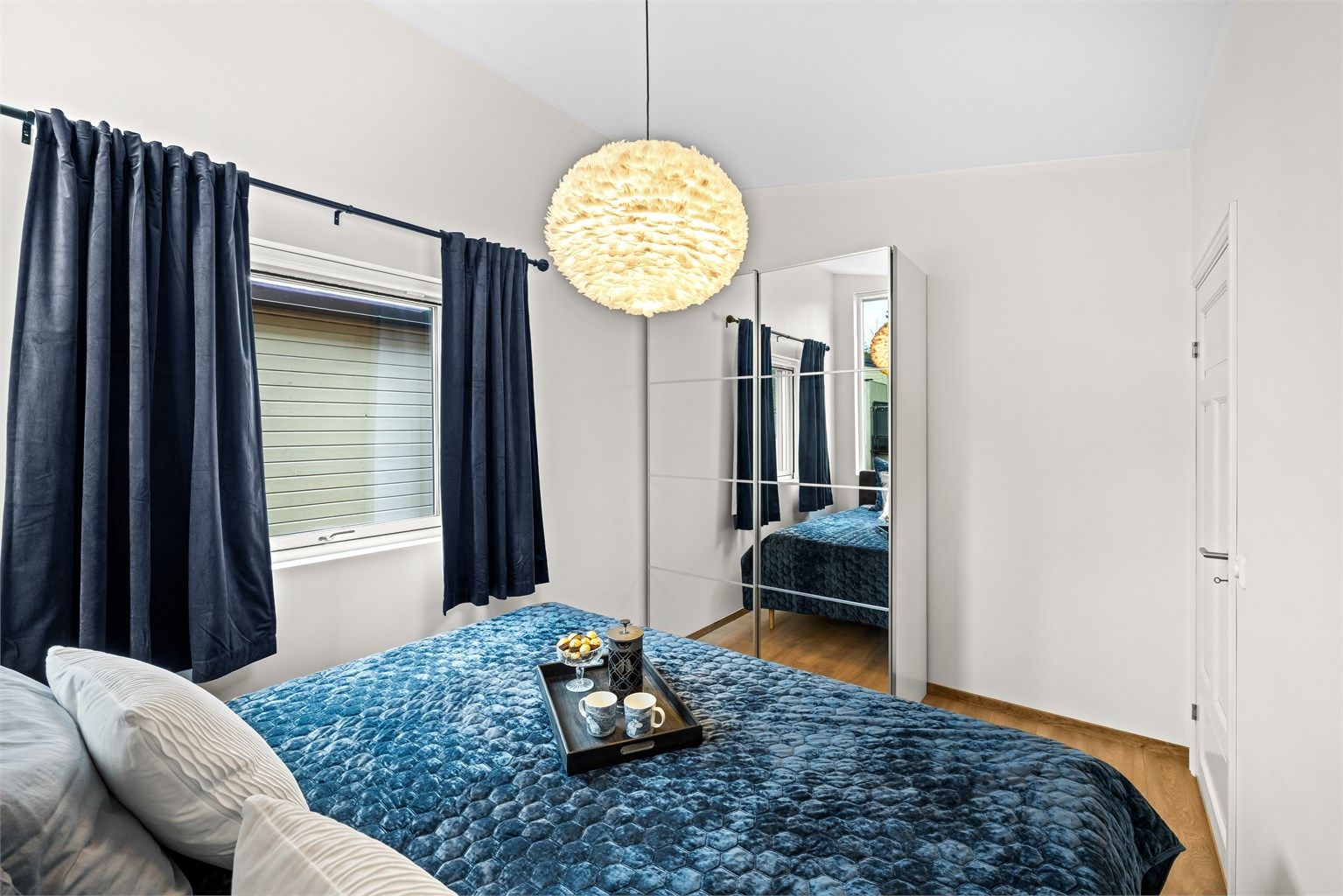 En stor skyvedørsgarderobe med speilfronter gir rikelig med oppbevaringsplass.