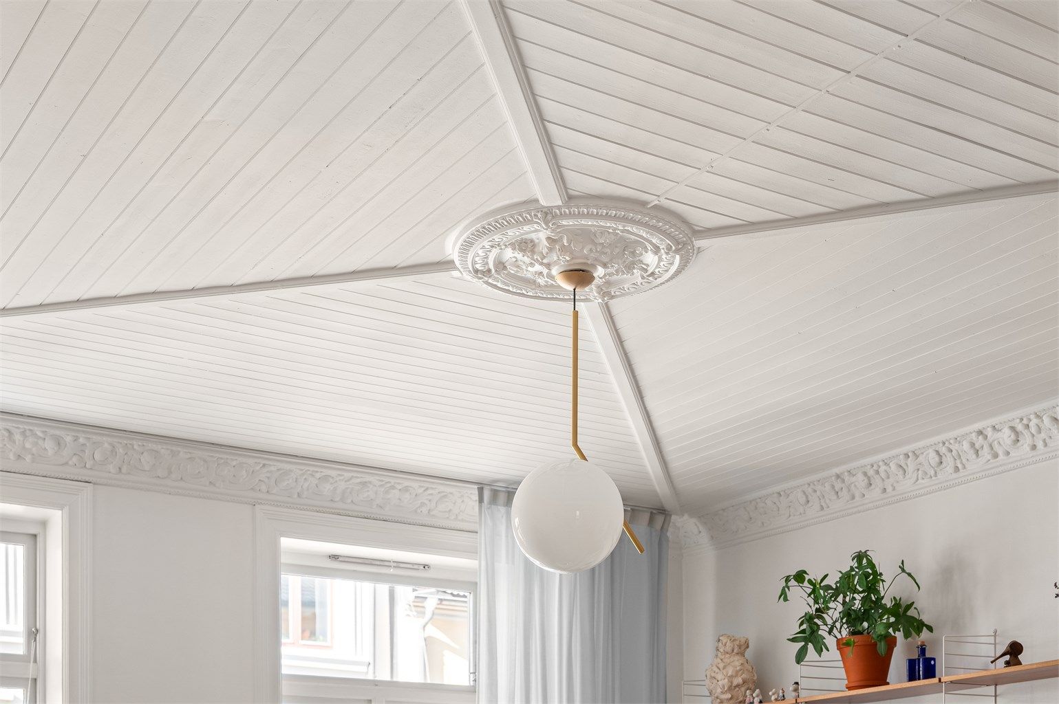 Stuen har en generøs takhøyde med en elegant rosett som et sentralt blikkfang.