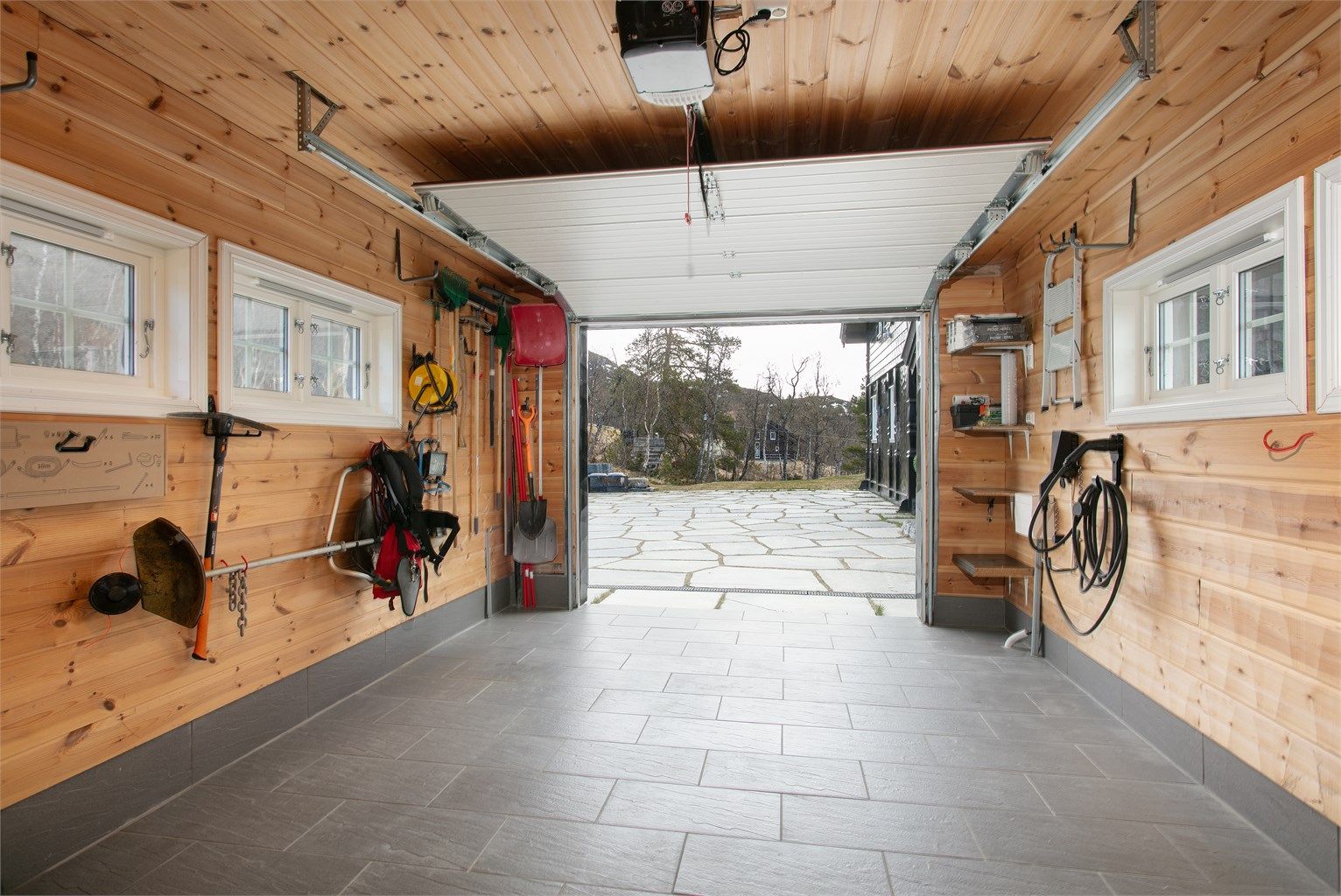 Fra garasjen er det direkte utgang til den skiferbelagte gårdsplassen.