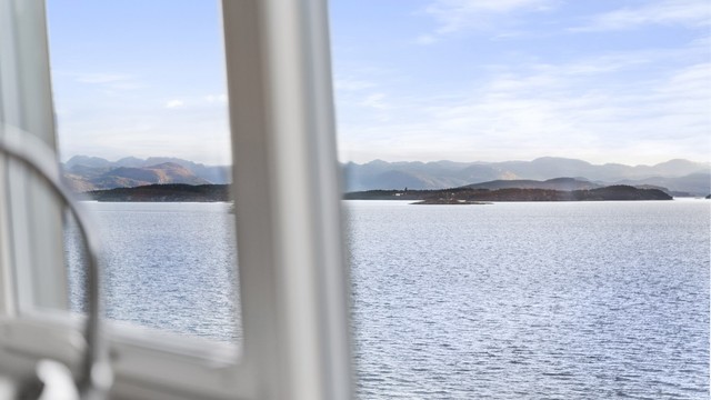 Flott utsikt fra kjøkken over maritime omgivelser.