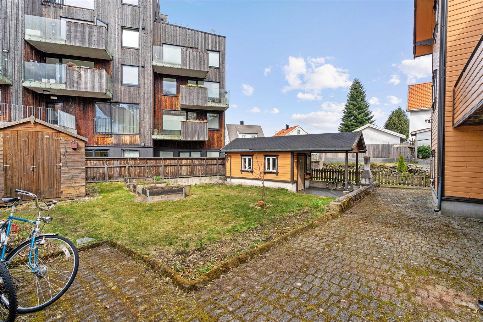 Felles uteområde med plen og belegningsstein.